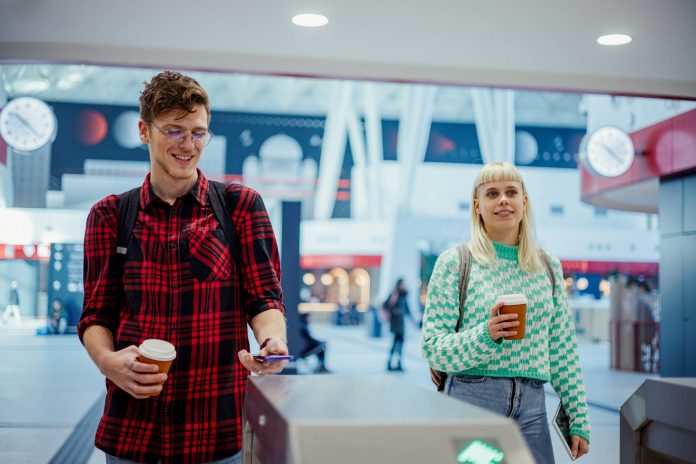 A man is paying his subway ticket with contactless e-banking mobile app.