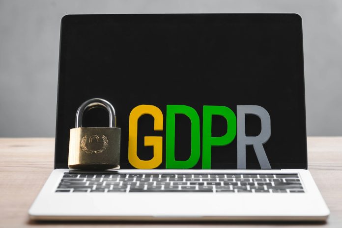 metal padlock and gdpr letters on laptop in office
